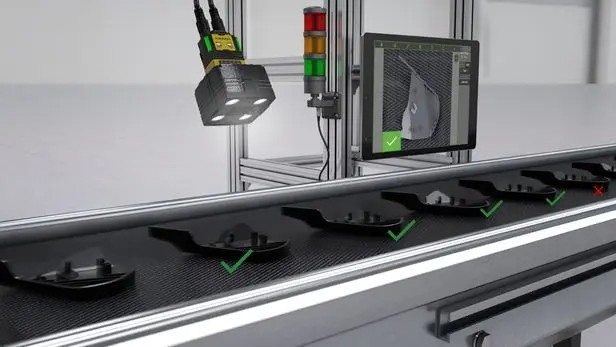 Camera inspecting parts on a conveyor with pass and fail indicators